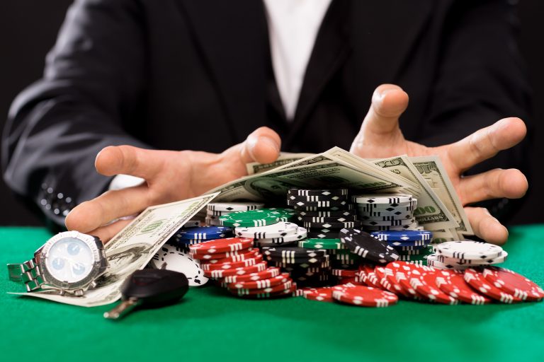 casino-gambling-people-entertainment-concept-close-up-poker-player-with-chips-money-personal-stuff-green-casino-table (1)